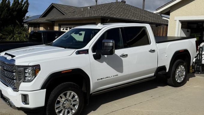White pickup truck parked in a driveway in front of a house