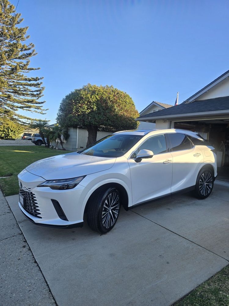 White SUV parked in a driveway in front of a garage