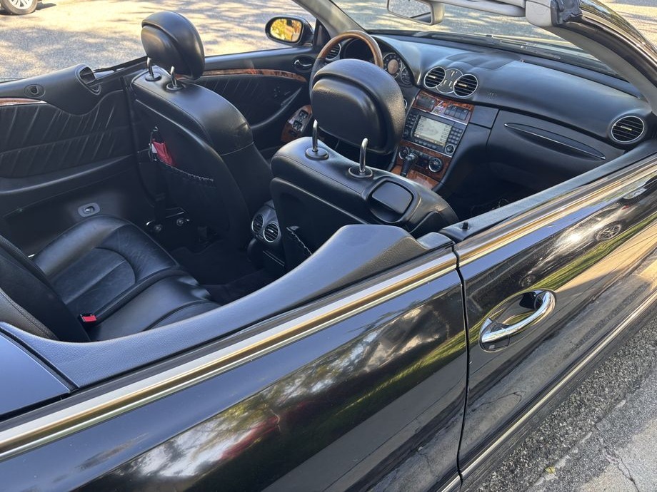 Open-top convertible with black leather seats and wood trim