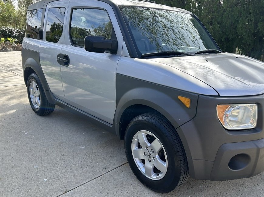 Silver boxy SUV parked in a sunny driveway