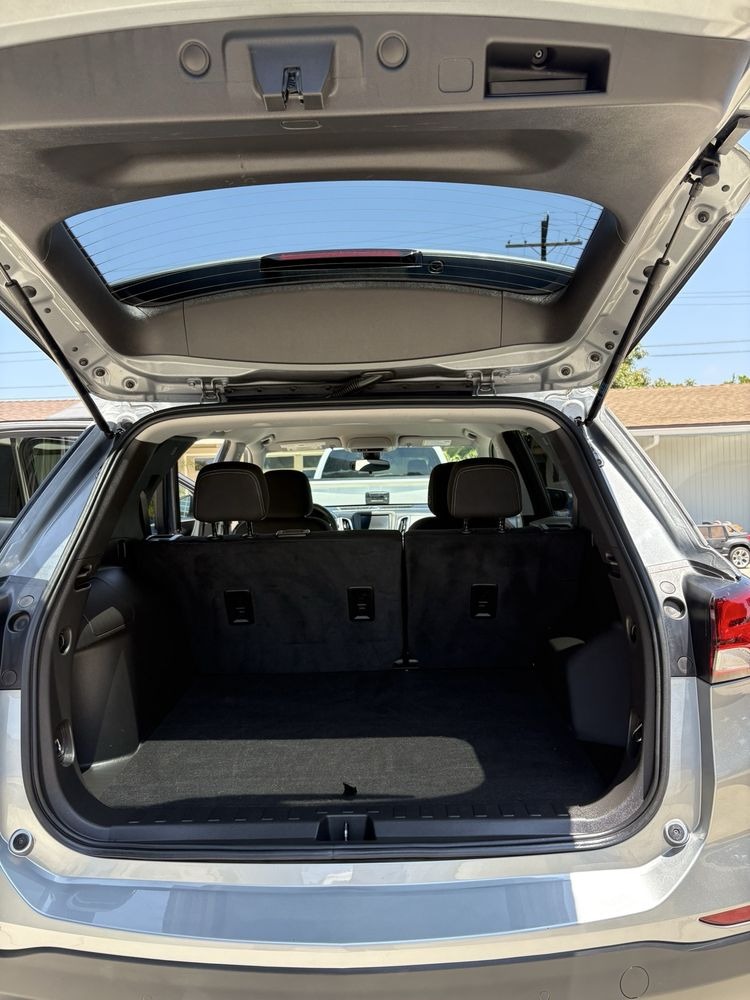 Open rear hatch of a silver SUV with an empty cargo area