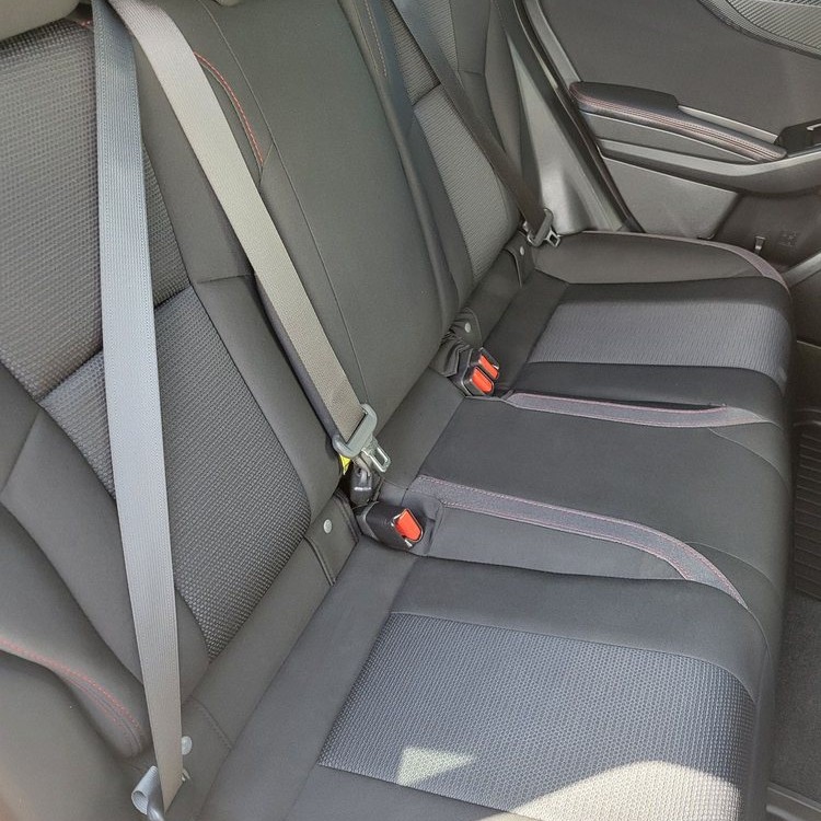 Rear cloth bench seat with seat belts inside a car